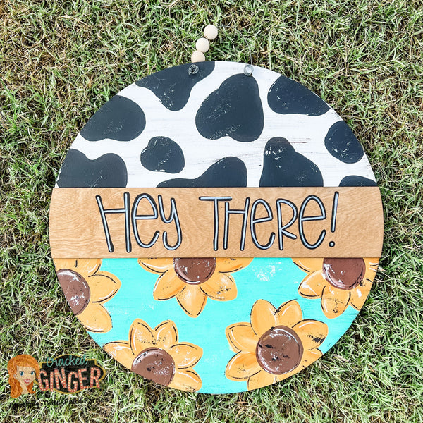 Cow print and Sunflowers Hey There Round Door Hanger Sign